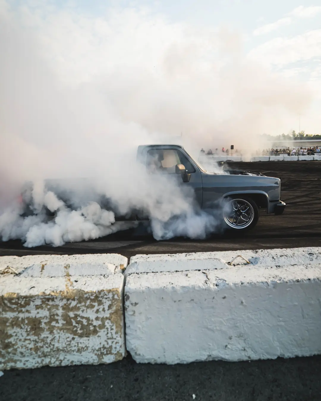Classic truck doing a smoky burnout in front of the crowd